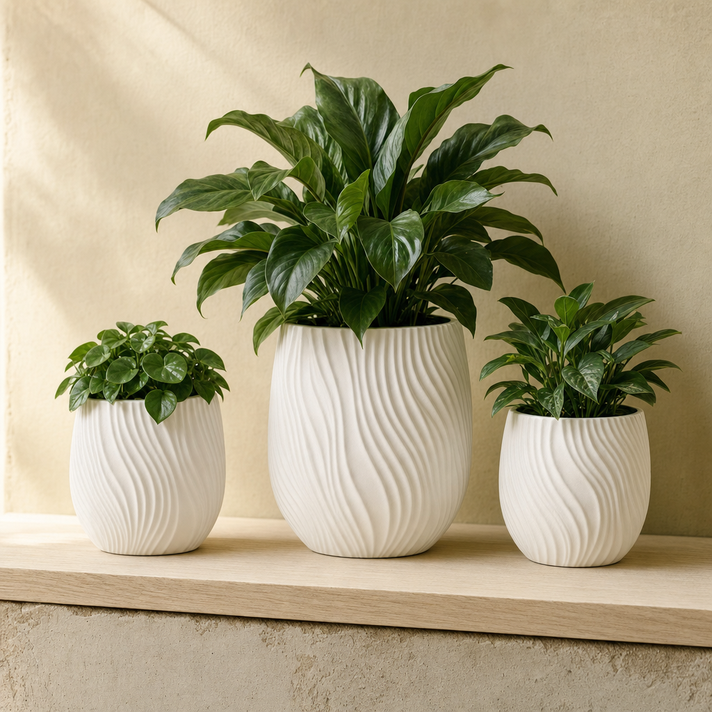 Drie witte designer plantenpotten met planten op een lichte houten plank